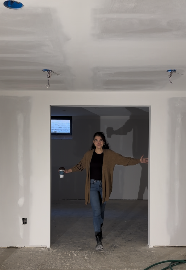 Drywall basement process. Women project manager walking with cup of coffee